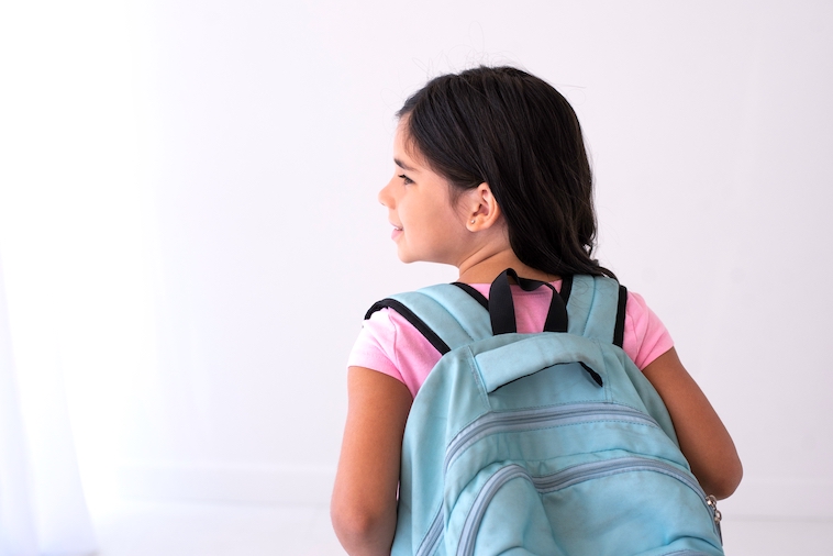 Girl with a blue backpack on - guide to backpack storage ideas.
