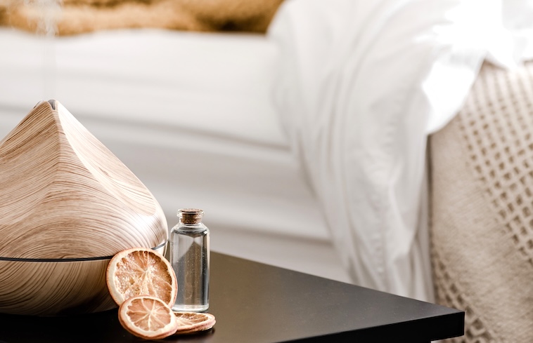 Bedside table with dried oranges, a diffuser, and essential oils - things you need for the perfect evening routine.