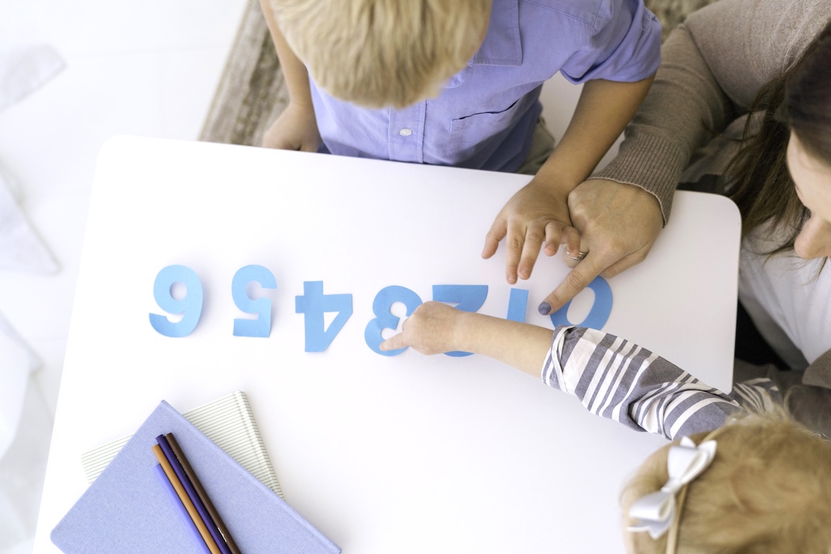 Child touching paper numbers - what to add to a back to school checklist.