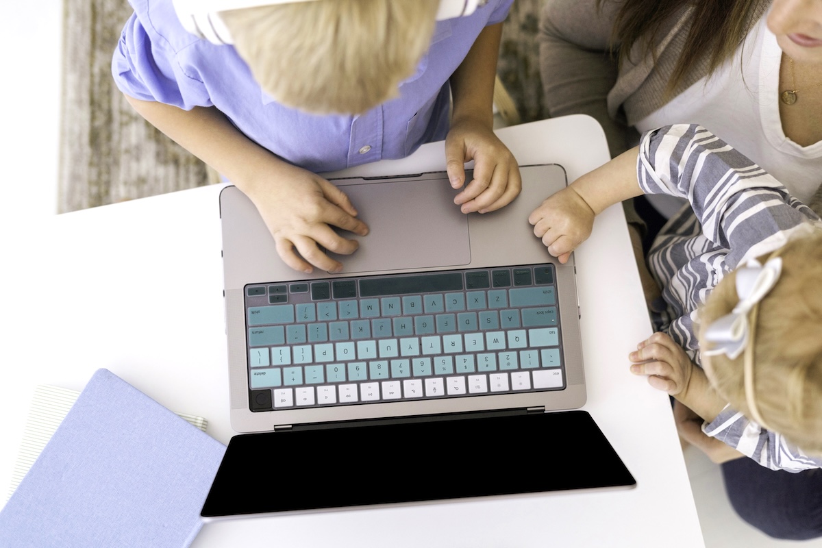 Child typing on laptop - what to add to a back to school checklist.