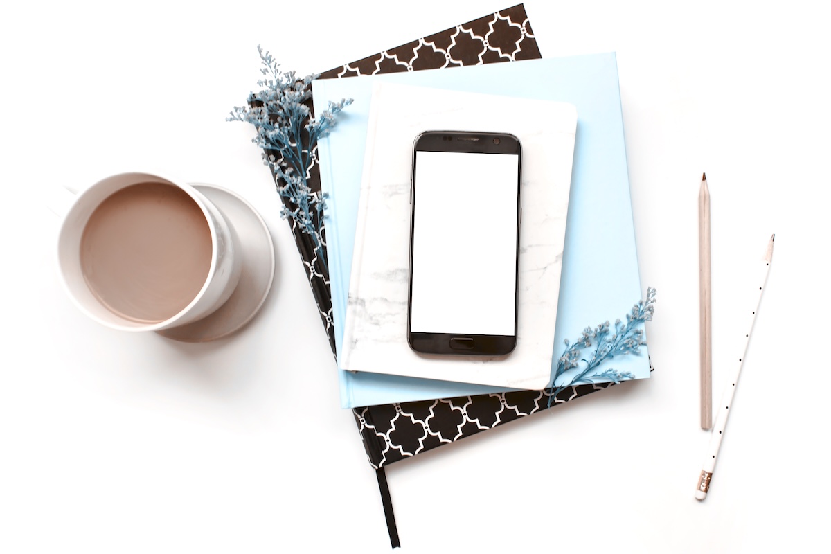 Tea, notebooks, and phone - digital declutter tools.