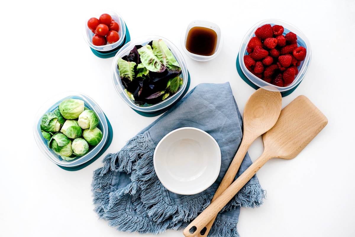 Bowl, wooden utensils, fruit and vegetables - things needed for family meal planning.