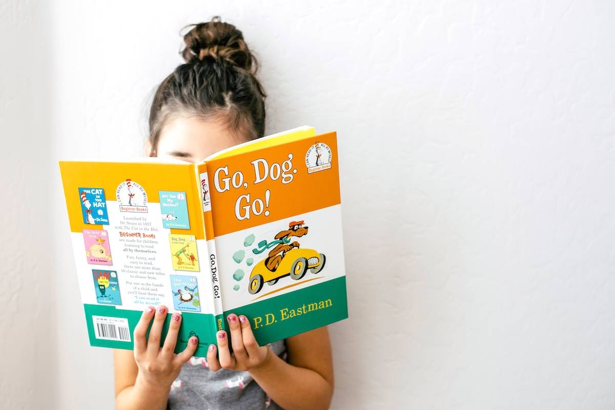 Girl reading book - a way to prepare for back to school.