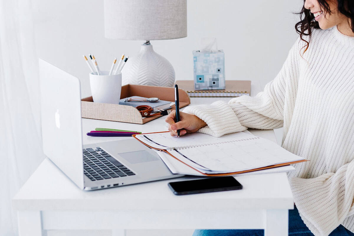 Woman writing in a planner - daily planners.