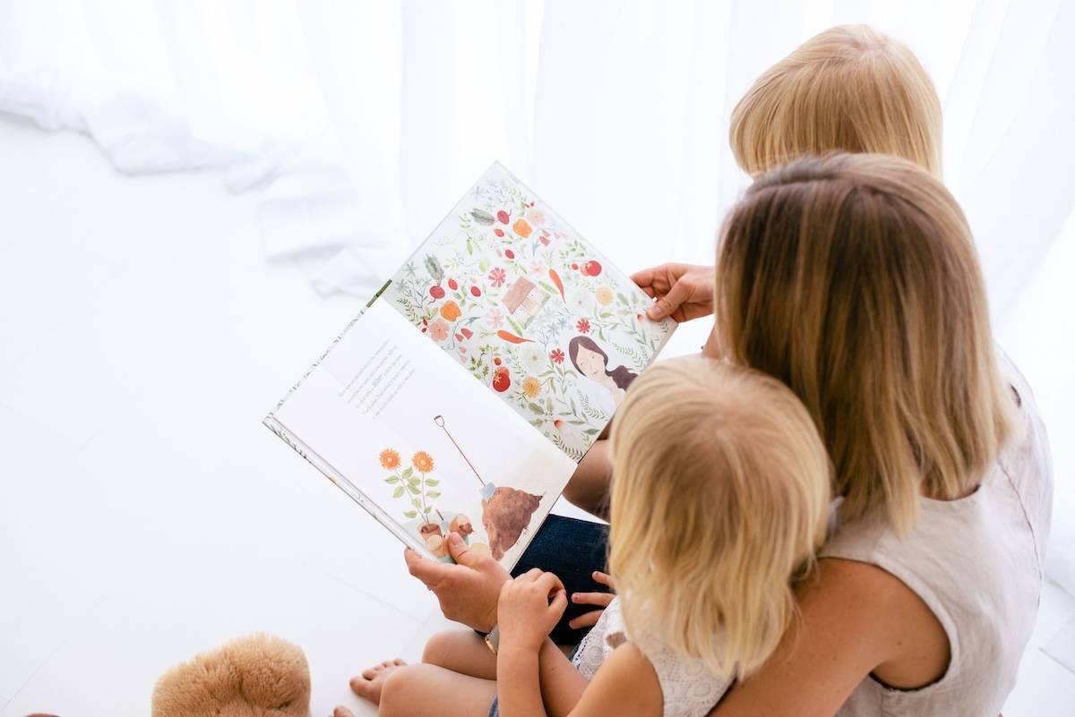 Woman reading to kids - family goals examples.