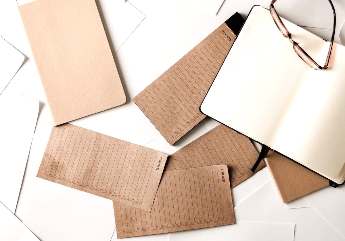 Piles of paper, notebook, pen - guide to decluttering paperwork.