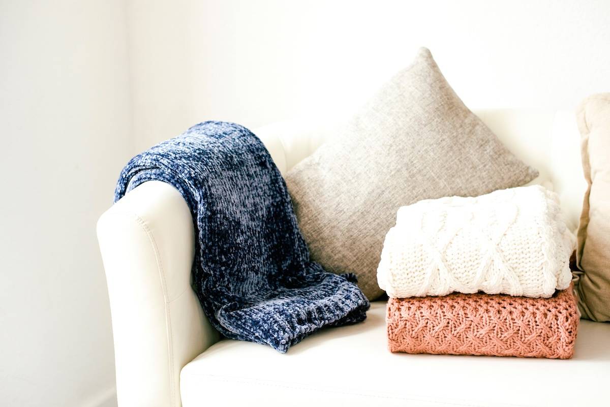 Sofa with cushion, 3 throws - decluttered living room tips.