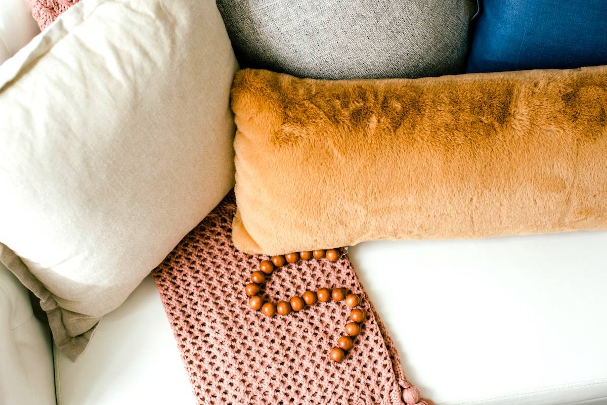 Sofa with 2 cushions and throw - decluttered living room tips.