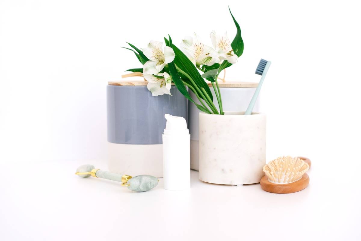 Toothbrush holder, flowers, bathing products - bathroom organisation items.