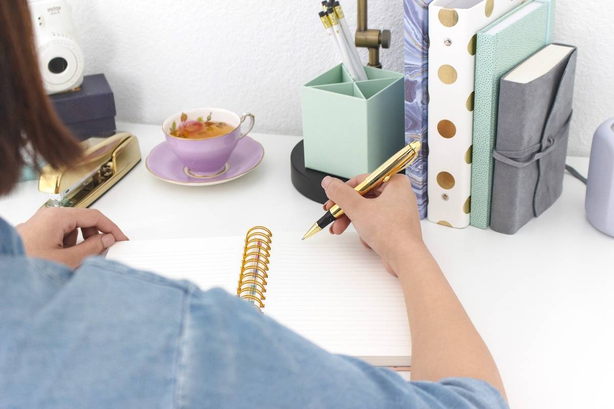 Woman writing in notebook - how to use family calendars.