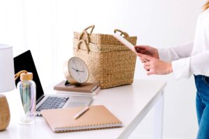 Women putting tablet into wicker basket - decluttering mindset.