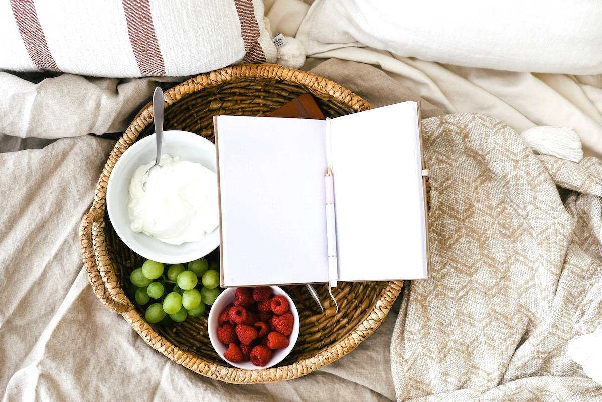 Yoghurt, fruit, notebook on blanket - freezer organisation tips for food items.