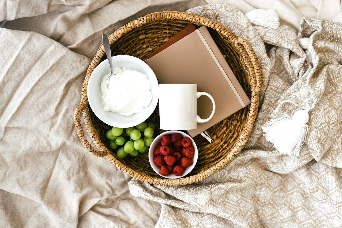 Yoghurt, fruit, notebook on blanket - freezer organisation tips for food items.