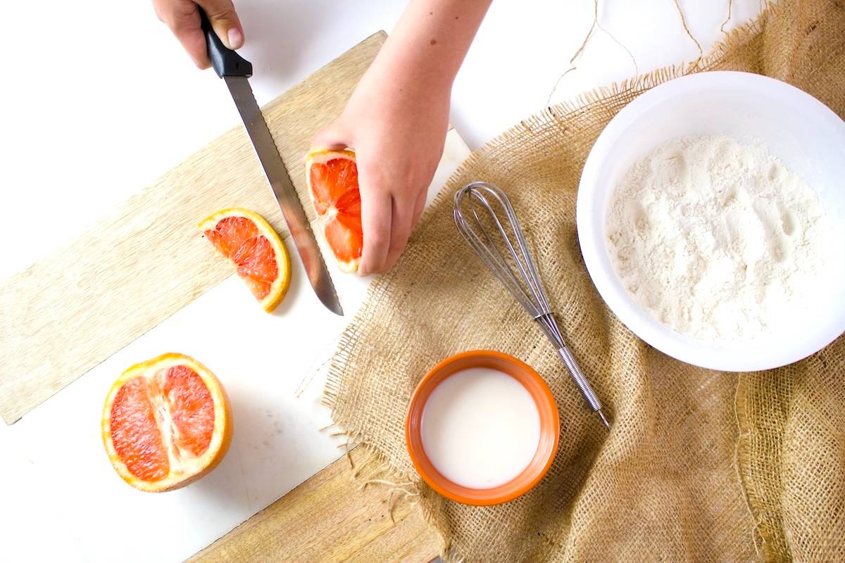 Person cutting grapefruit - dinner theme night ideas to try.