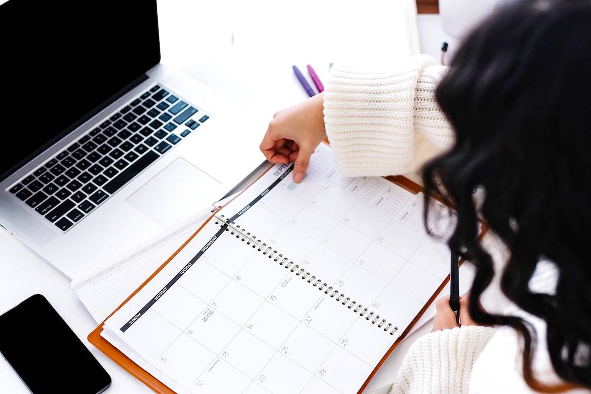 Woman putting sticker in planner - family organisation items.