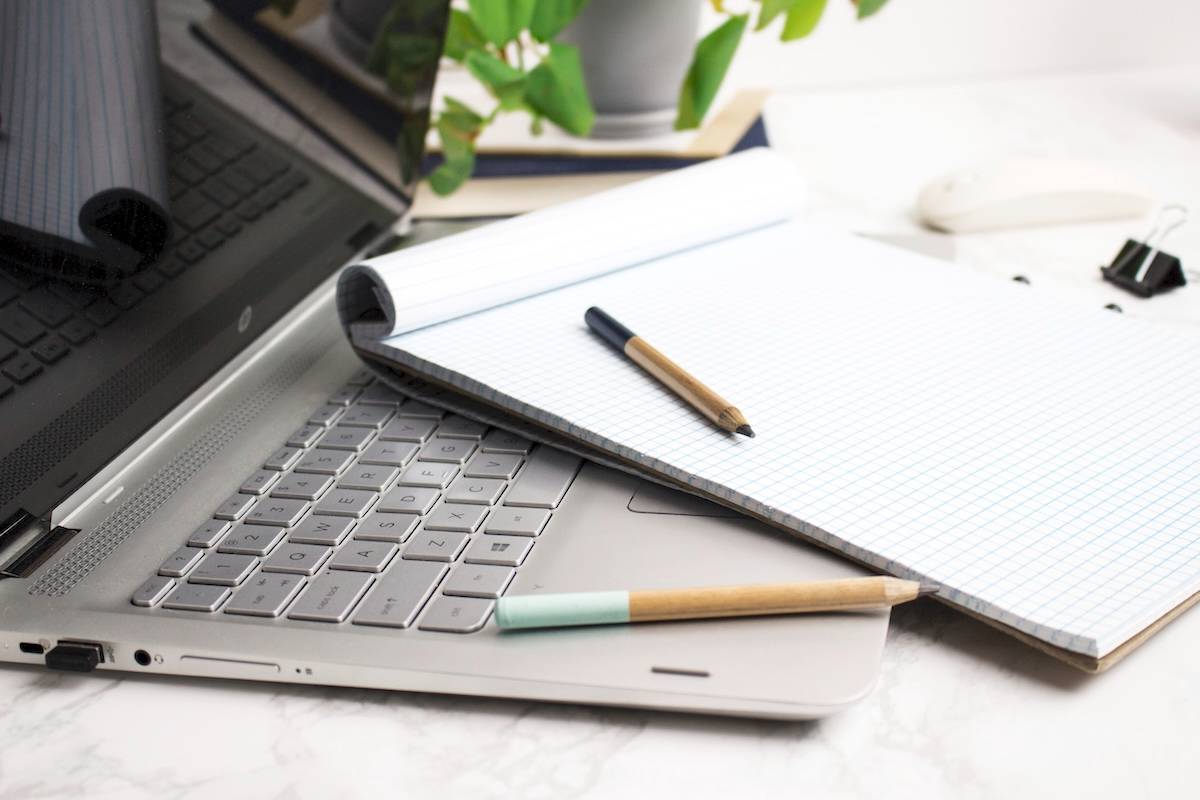 Laptop, notebook, pen - tips for how to be productive.