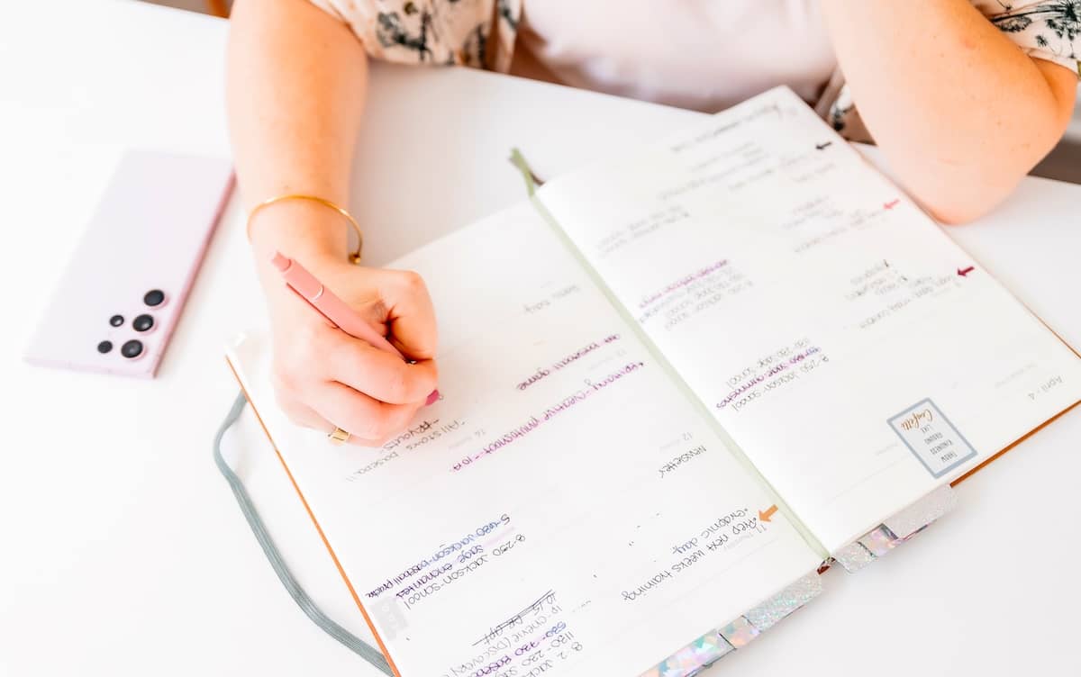 Woman writing in journal - tips for how to be productive.