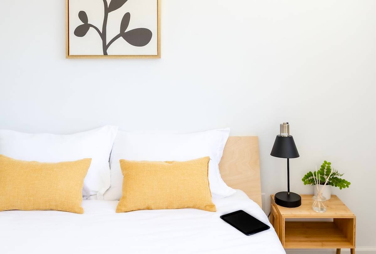 Bed with tablet and side table - tips for how to declutter your home.