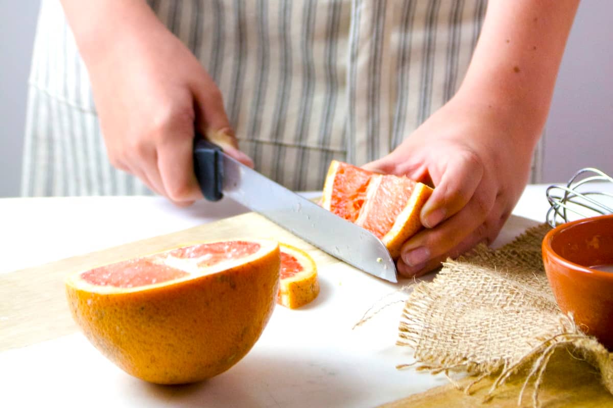 Person cutting grapefruit - items needed for family meal planning.