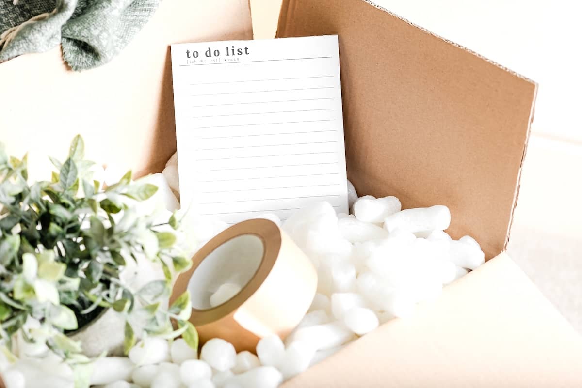 Moving box with packing tape and to do list - tips for moving houses.