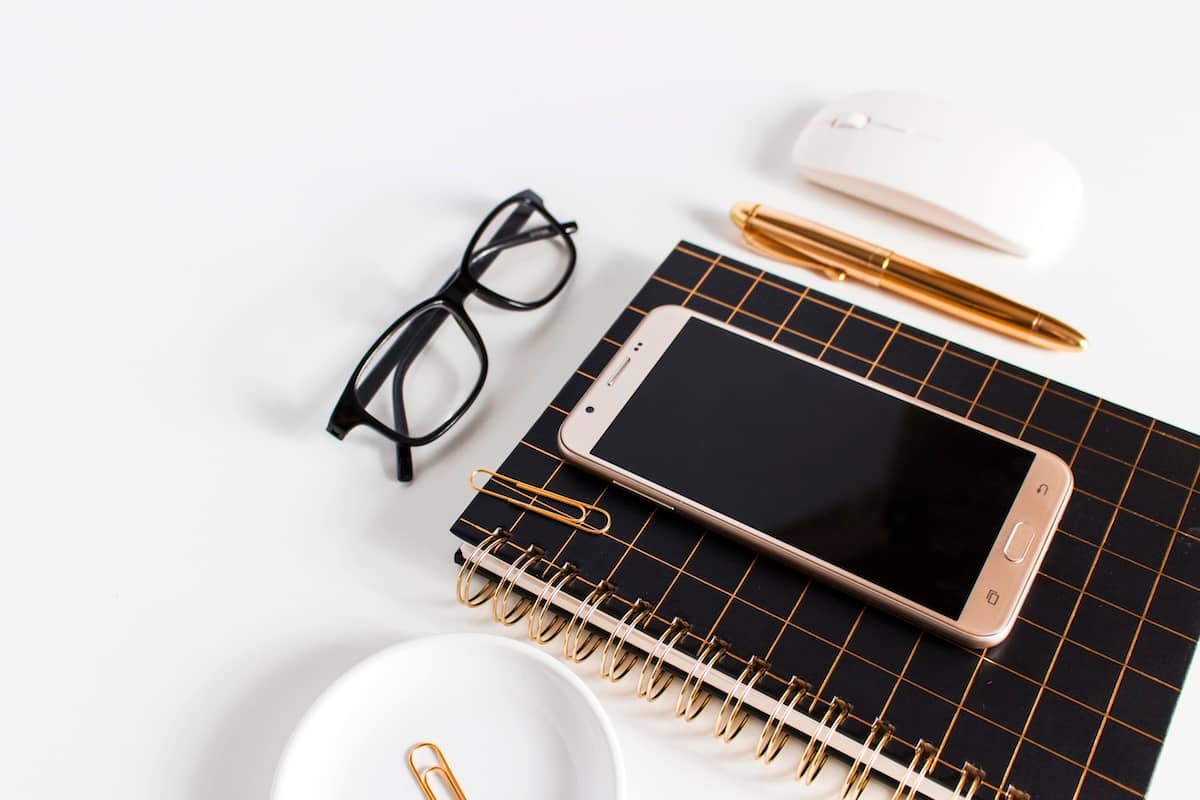 Glasses, phone, stationery - items to help decide how to choose a planner.
