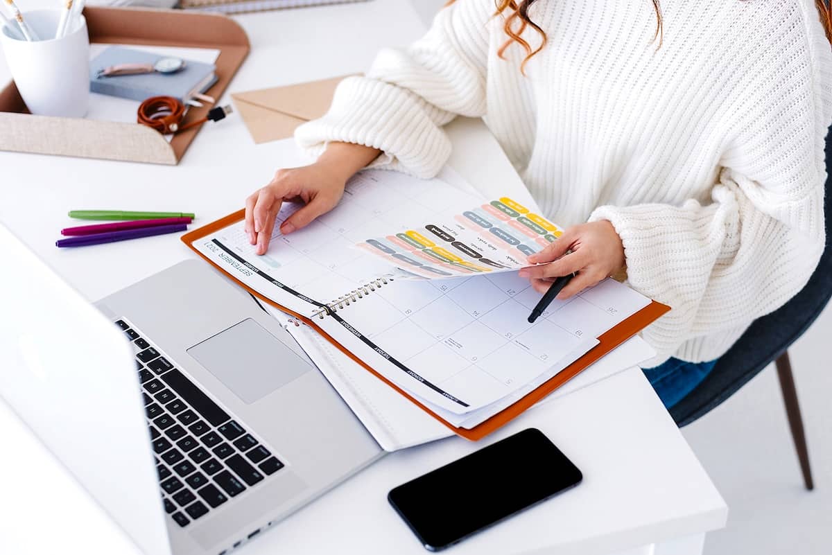 Women writing in a planner - tips to tackle an overwhelming to-do list.