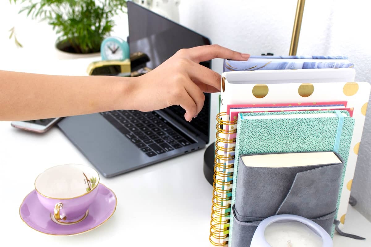 Woman selecting planner - daily routine ideas to try.