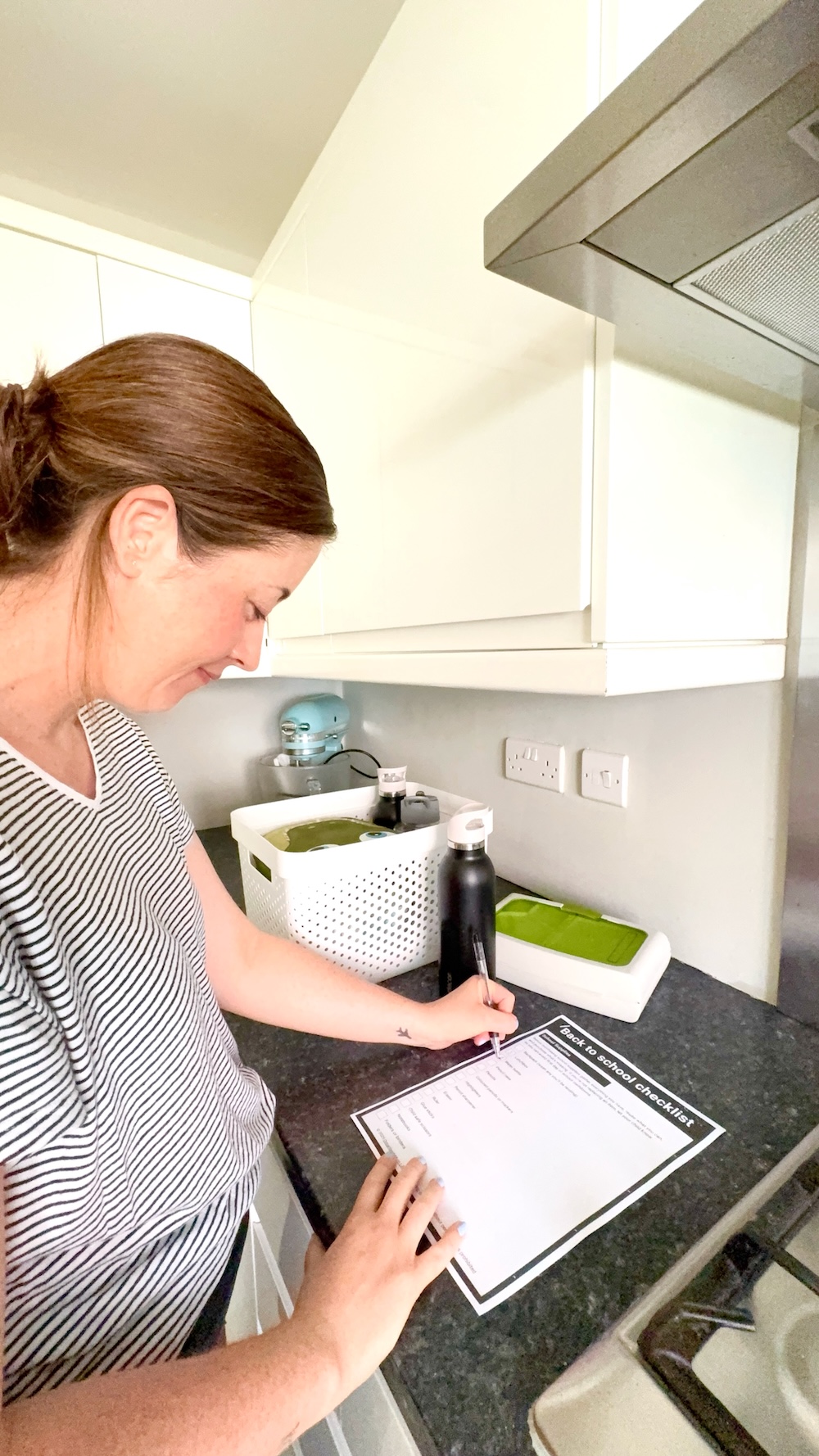 Woman filling in back to school checklist - free resources for busy mums